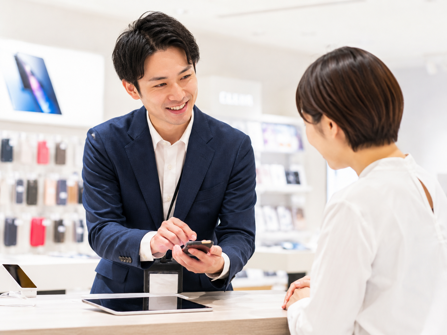 携帯端末をご案内する男性スタッフ